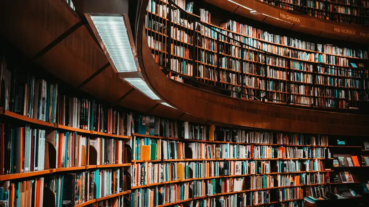 The curved shelves of a large library, filled with books