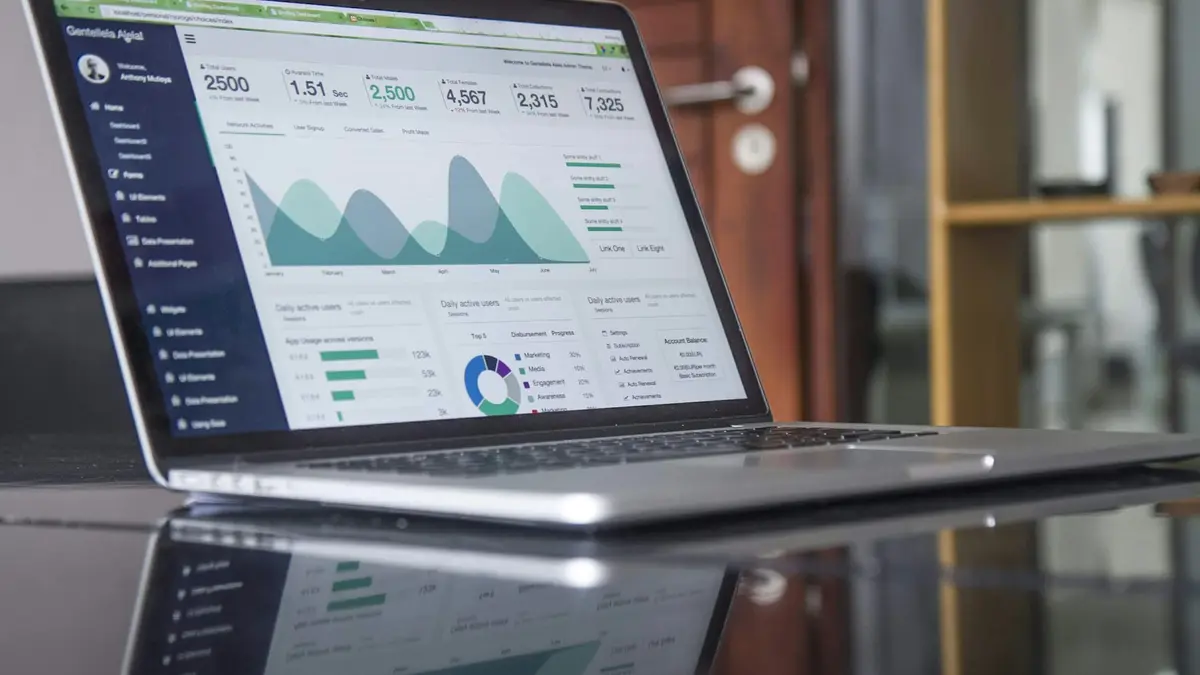 A laptop on a desk showing line and bar charts